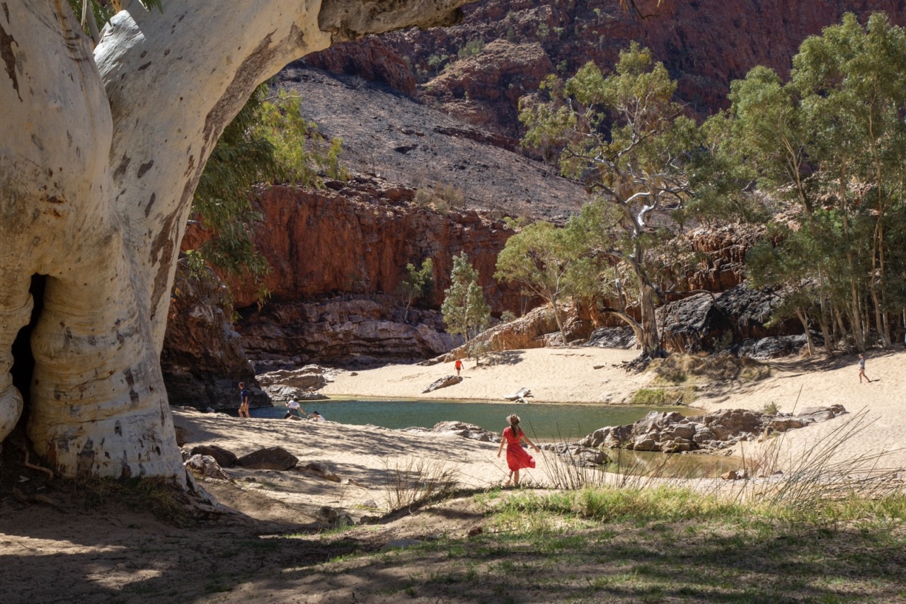 Frau am Wasserloch in den MacDonnell Ranges im Roten Zentrum, Northern Territory